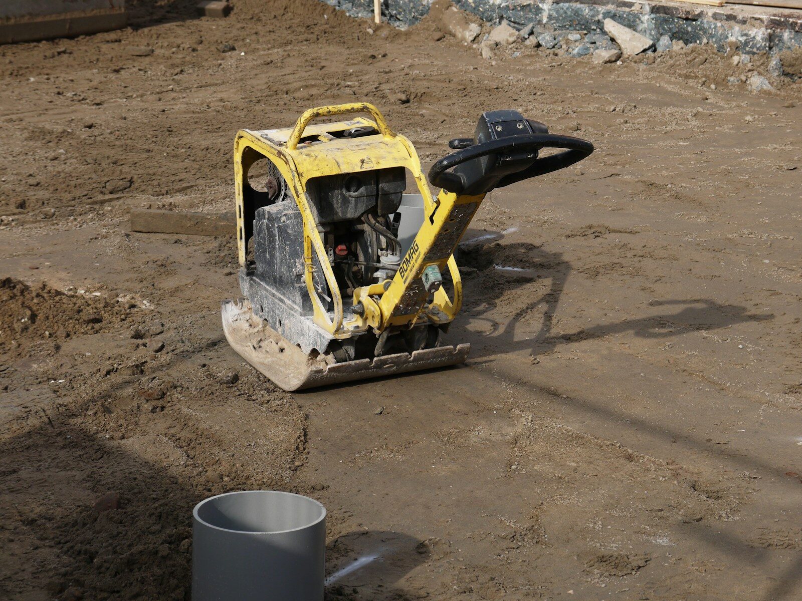 yellow and black excavator on brown sand